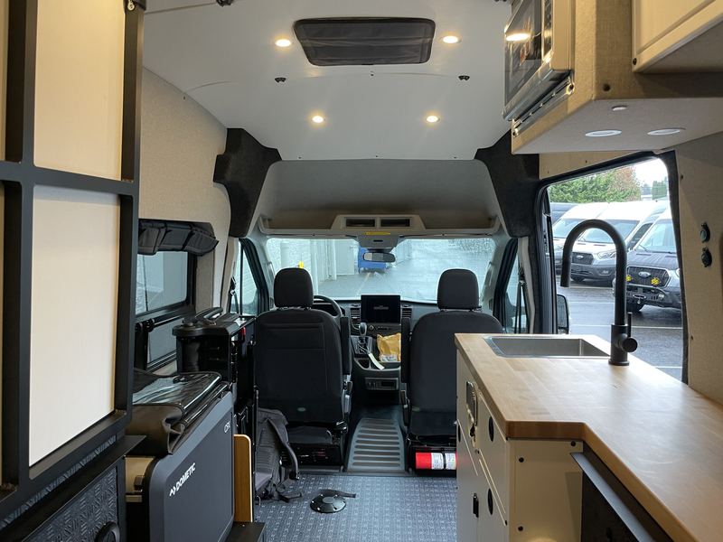 Interior looking toward the cab with sink, cabinets and swivel seats