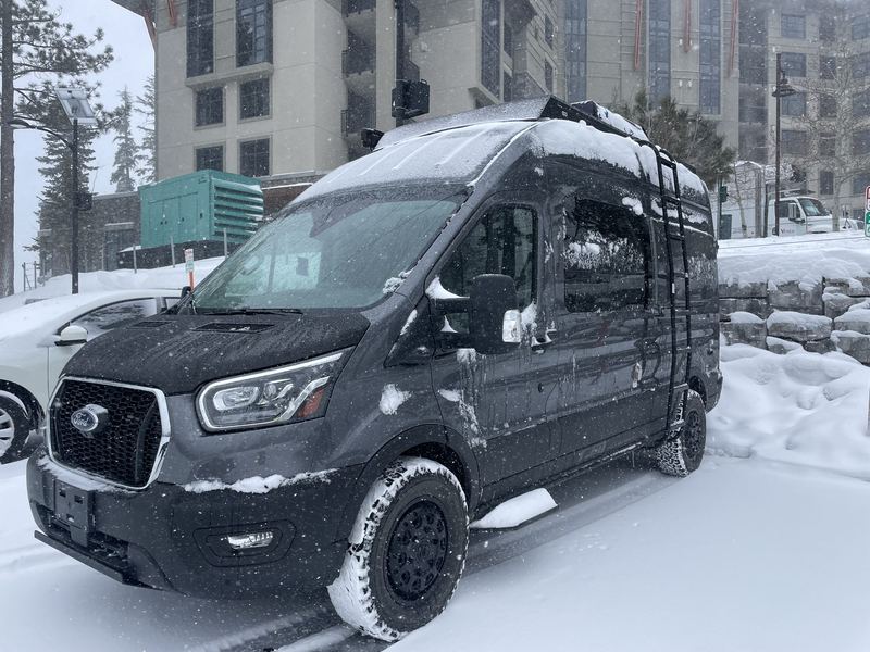 Van dusted in snow outside a mountain lodge